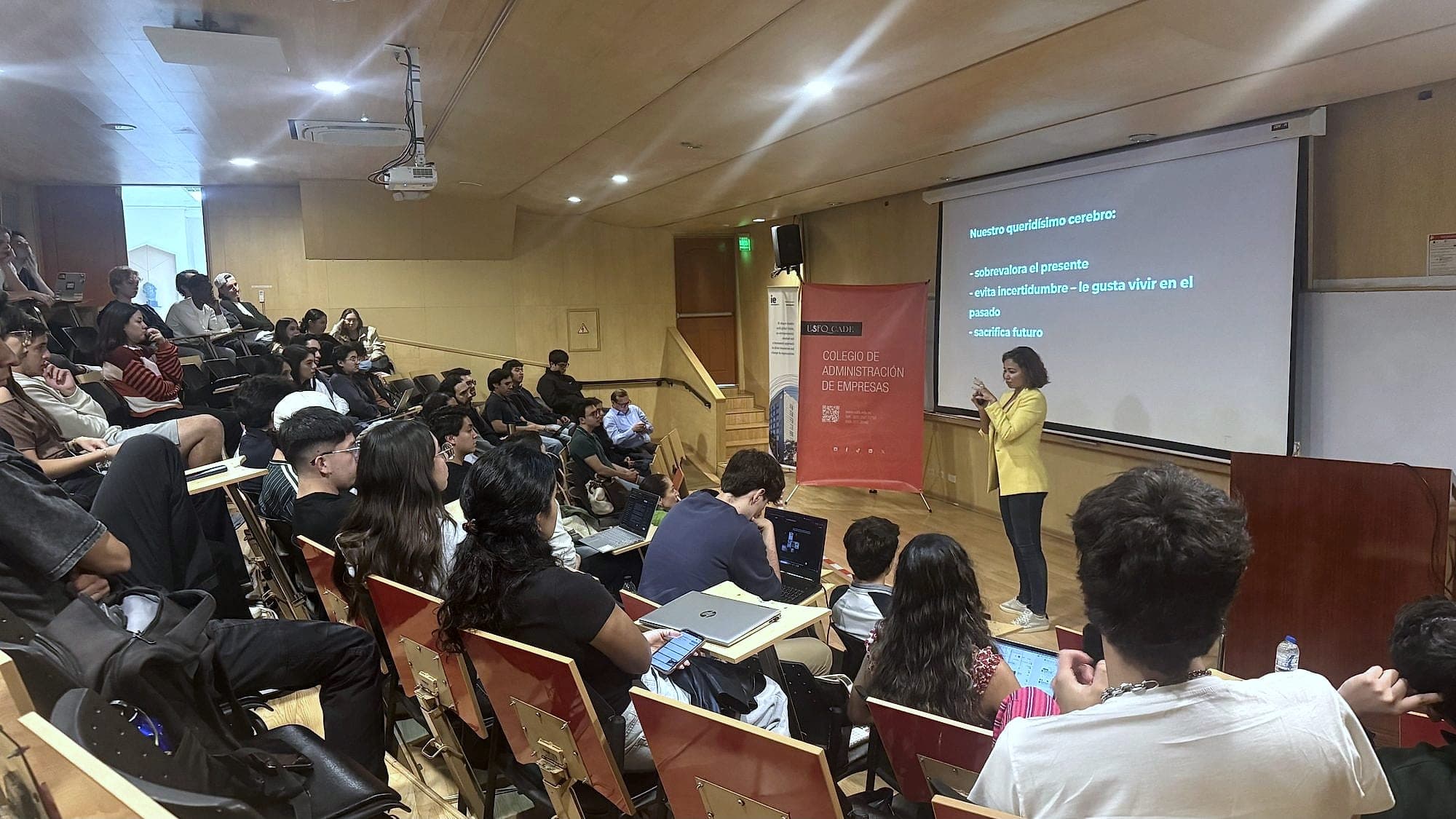 Sam Hernández García lecturing on how the brain makes decisions to a full university lecture hall